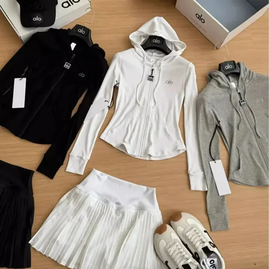 Coordinated black, white and grey activewear pieces with a pleated skirt and trainers